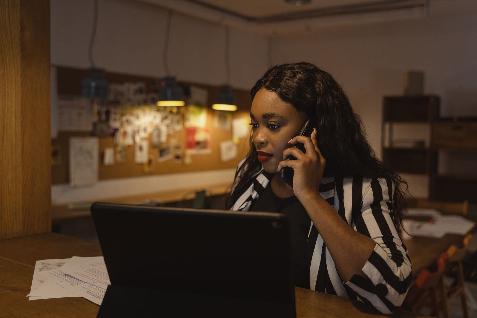 Person on the phone reviewing short term disability for mental health claim paperwork at a desk