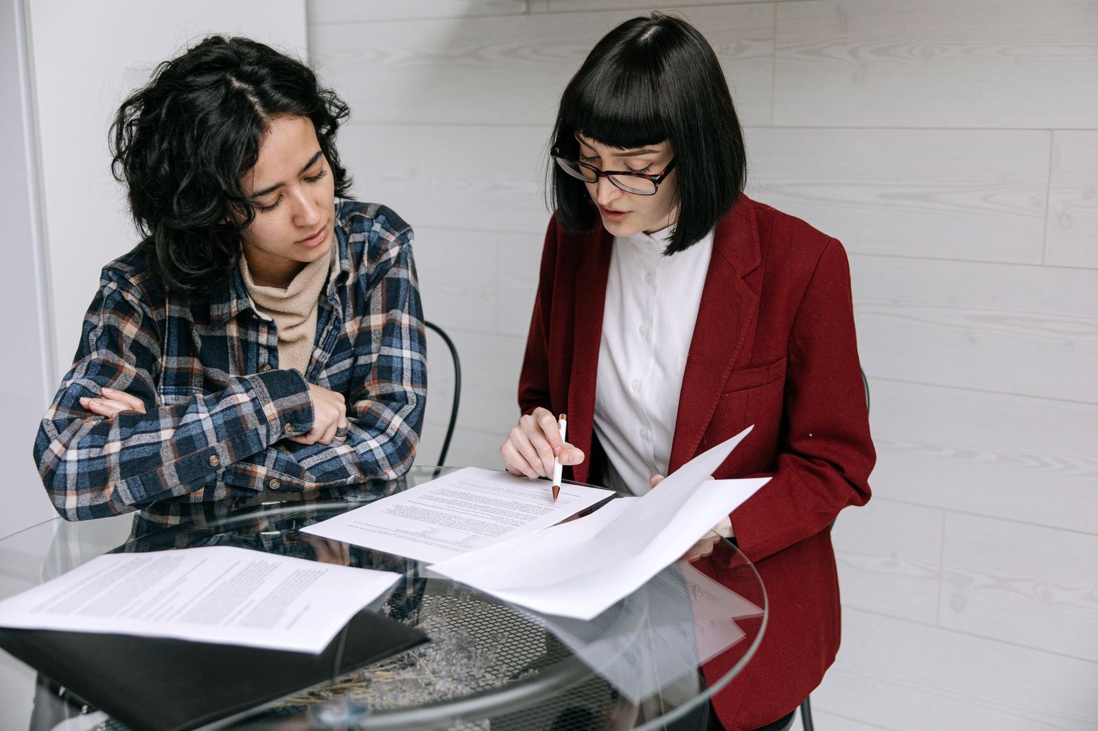 Two people comparing a psychiatric hospital bill with an explanation of benefits at a table